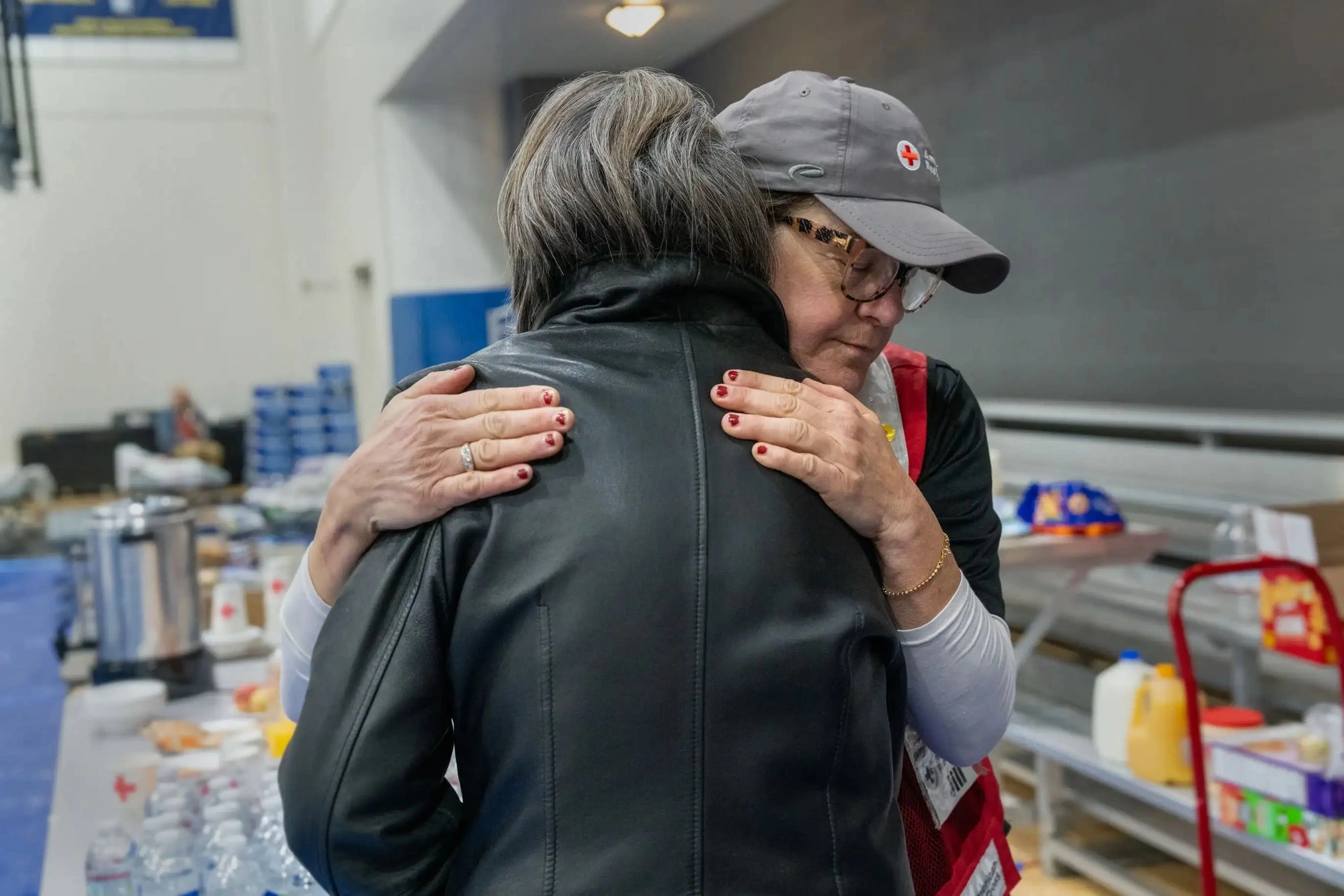 Two people hugging inside a relief donation center