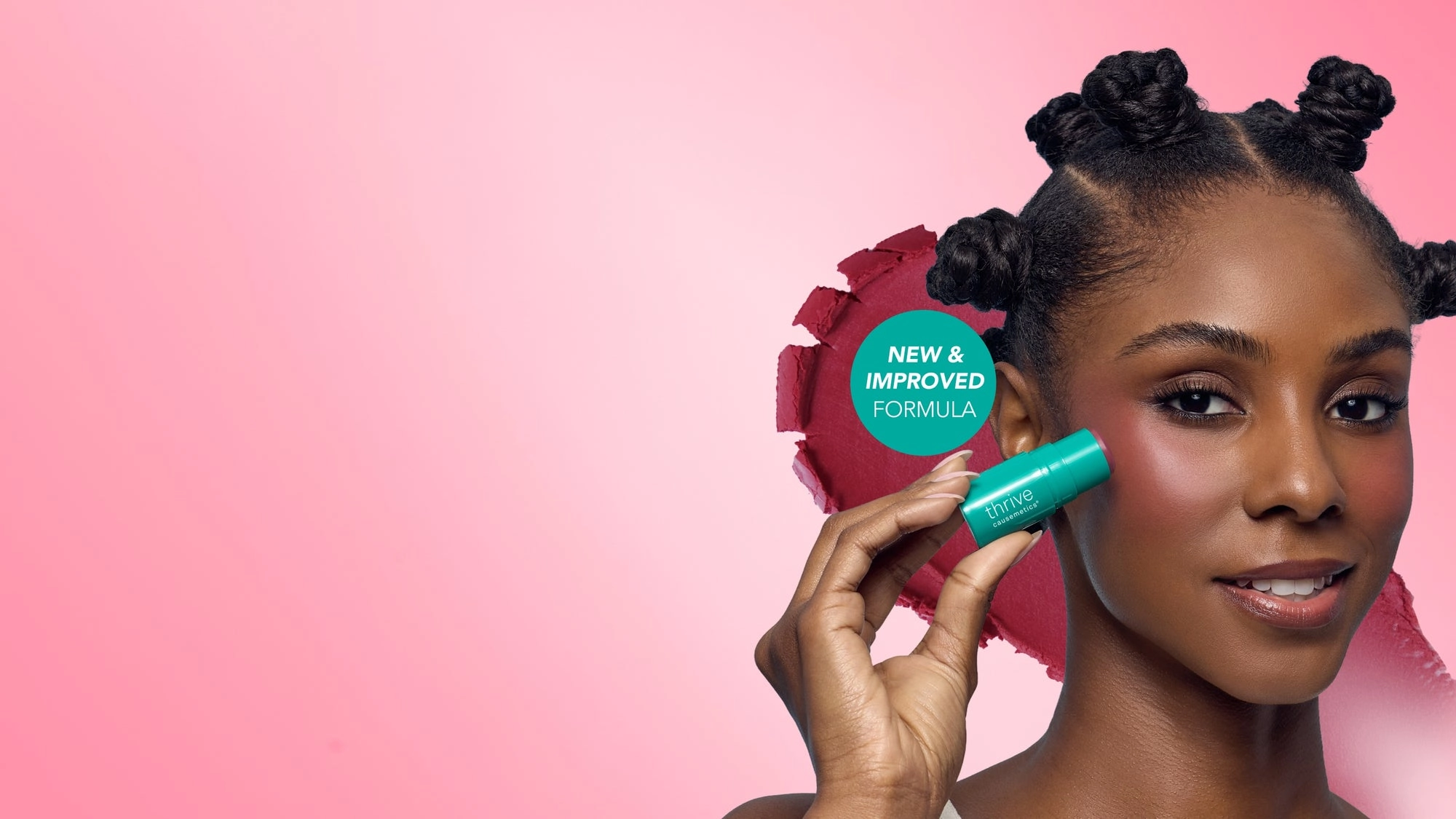 Woman with a pink backdrop and a turquoise stick near her eye